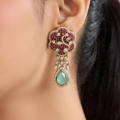 Designer ruby red kundan choker necklace set with sparkling crystal detailing, mint green teardrop gemstone centerpiece, and matching earrings for bridal and festive occasions.