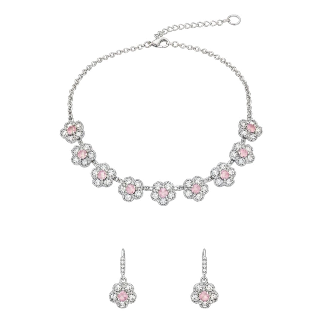 Silver floral necklace and matching earrings set with sparkling round crystals displayed on a red velvet jewelry stand, perfect for weddings and festive occasions.