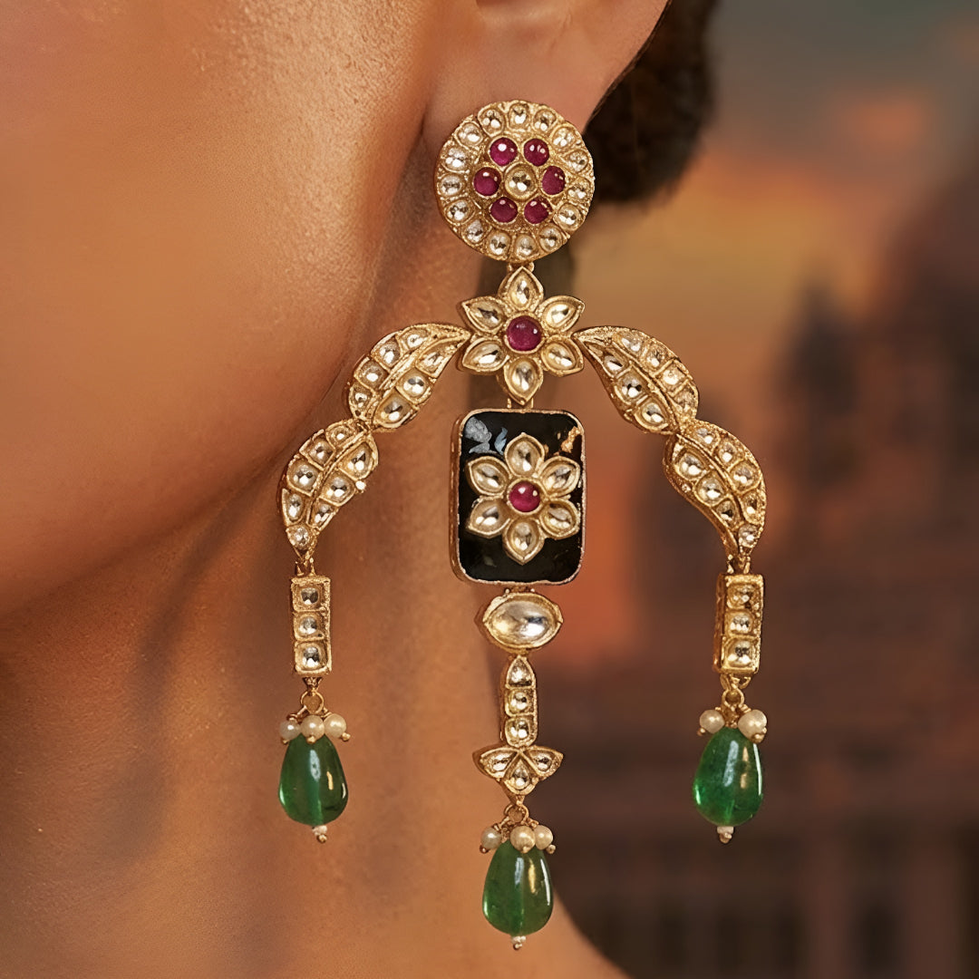 Designer gold-plated kundan necklace set with floral enamel motifs, pink stone accents, sparkling white kundan work, green bead drops, and matching statement earrings.