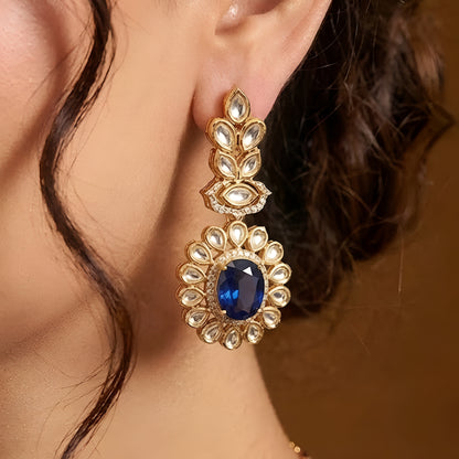 Gold-tone Kundan-inspired necklace and earrings set featuring white stones and deep purple oval gemstone accents in an elegant traditional design.
