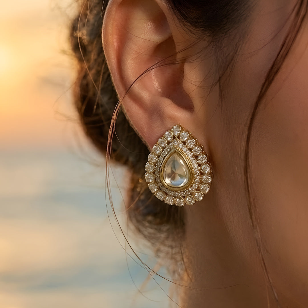 Multi-strand pearl choker necklace featuring a teardrop Kundan pendant with matching stud earrings on a white background.