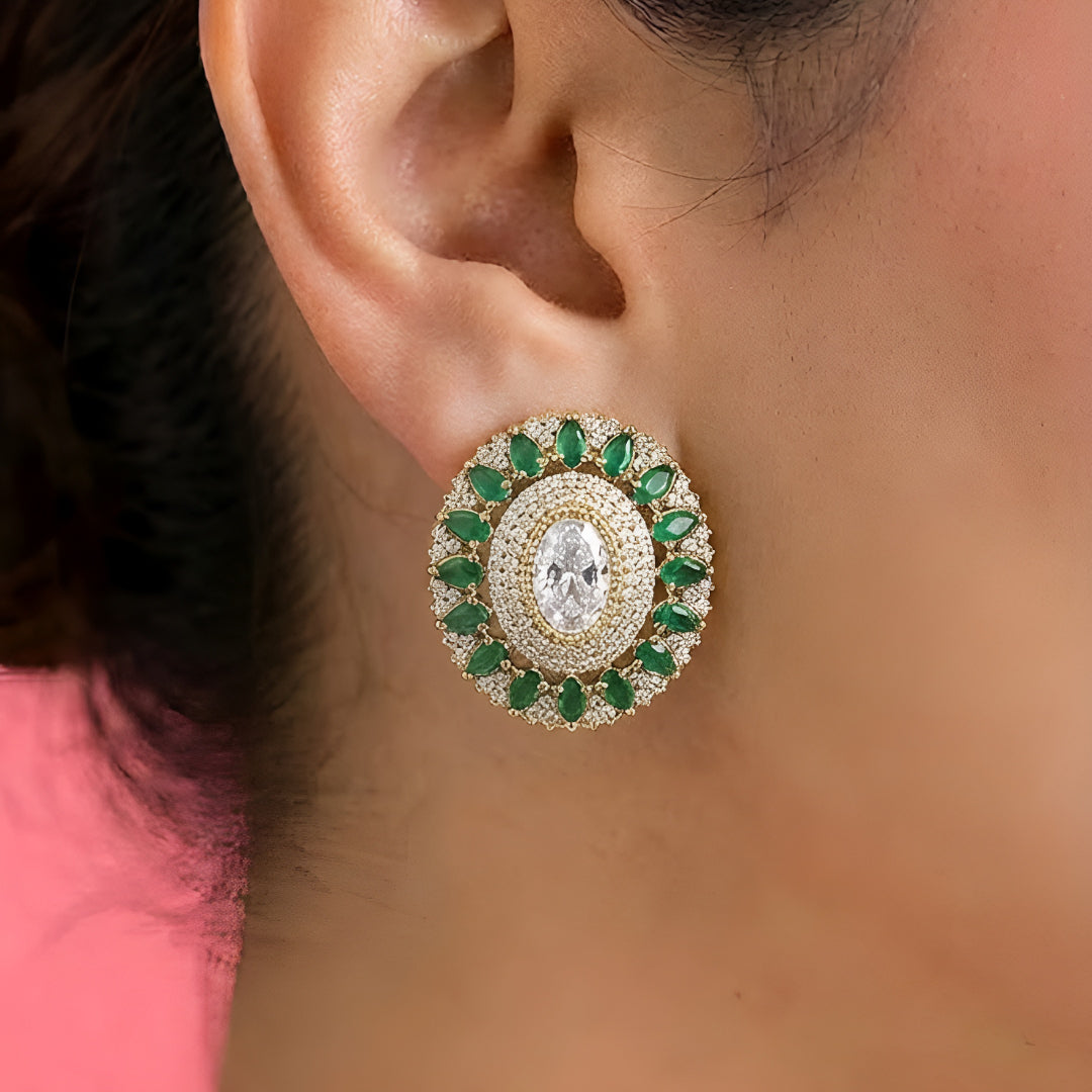 Elegant diamond and emerald choker necklace set with matching stud earrings featuring intricate floral motifs, sparkling white stones, green gemstone accents, and a luxurious gold-tone finish.