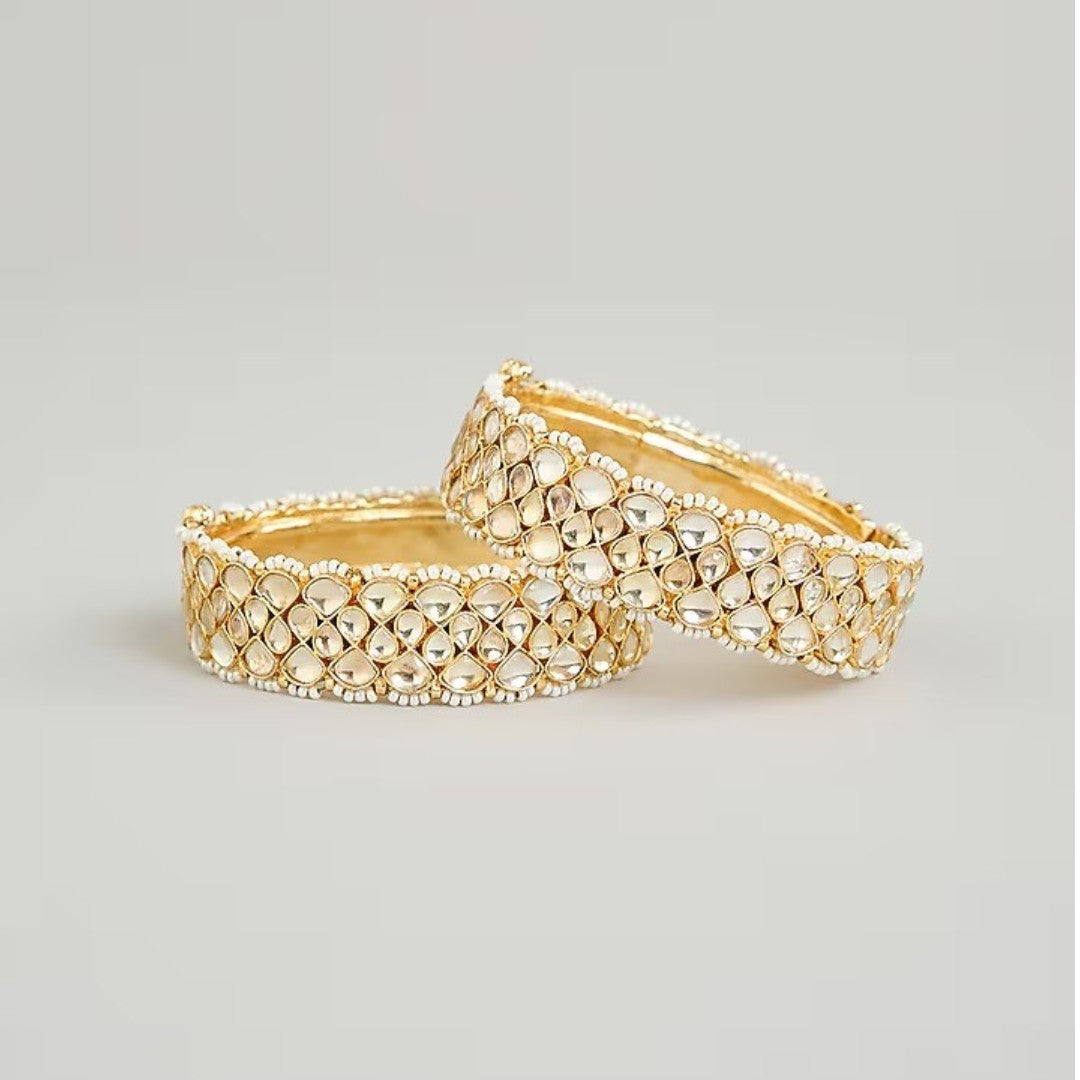 Gold-plated Kundan bangles with teardrop stones and pearl bead detailing for women, ideal for bridal and festive wear.
