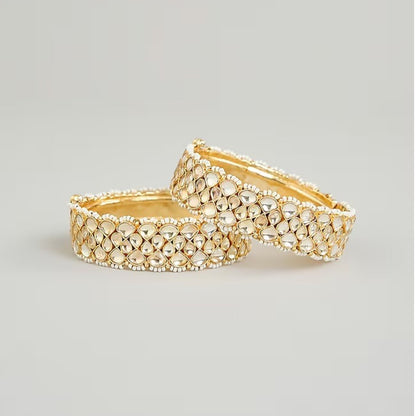 Gold-plated Kundan bangles with teardrop stones and pearl bead detailing for women, ideal for bridal and festive wear.