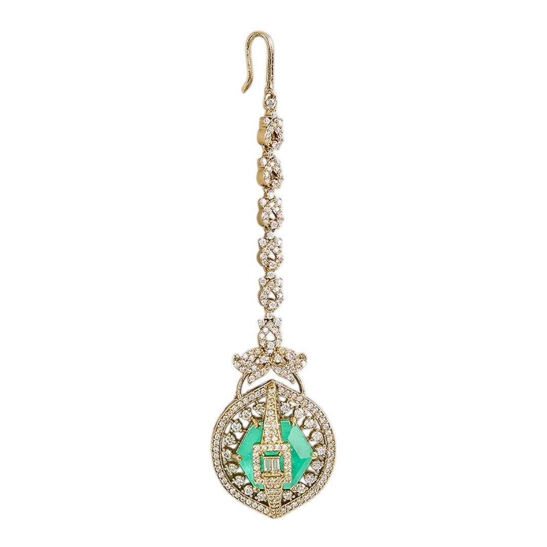 Gold-plated American Diamond maang tikka with an emerald-green center stone and circular pendant for bridal and festive wear.
