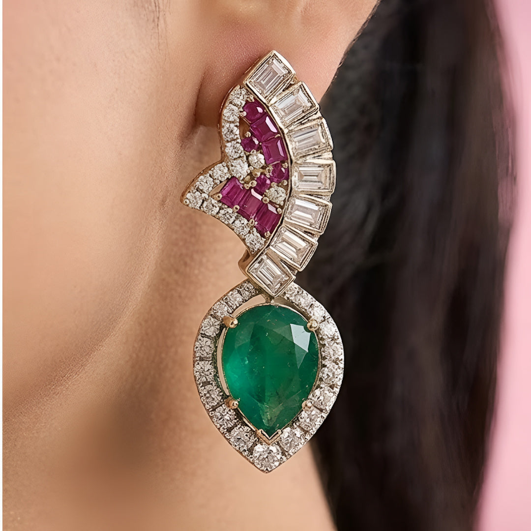 Luxury emerald, ruby and diamond necklace set with matching earrings in white gold featuring pear-shaped emerald gemstones, pink ruby accents and sparkling diamond detailing.