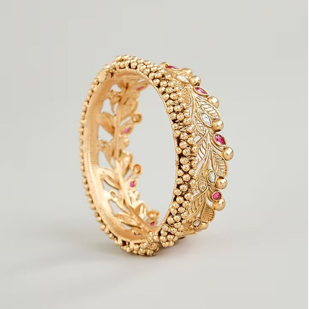Gold-plated leaf design kada bangles with red and white stone embellishments for women.