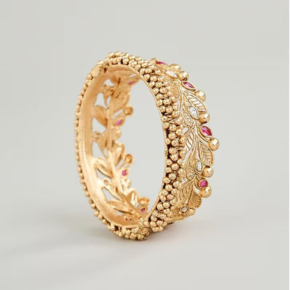 Gold-plated leaf design kada bangles with red and white stone embellishments for women.