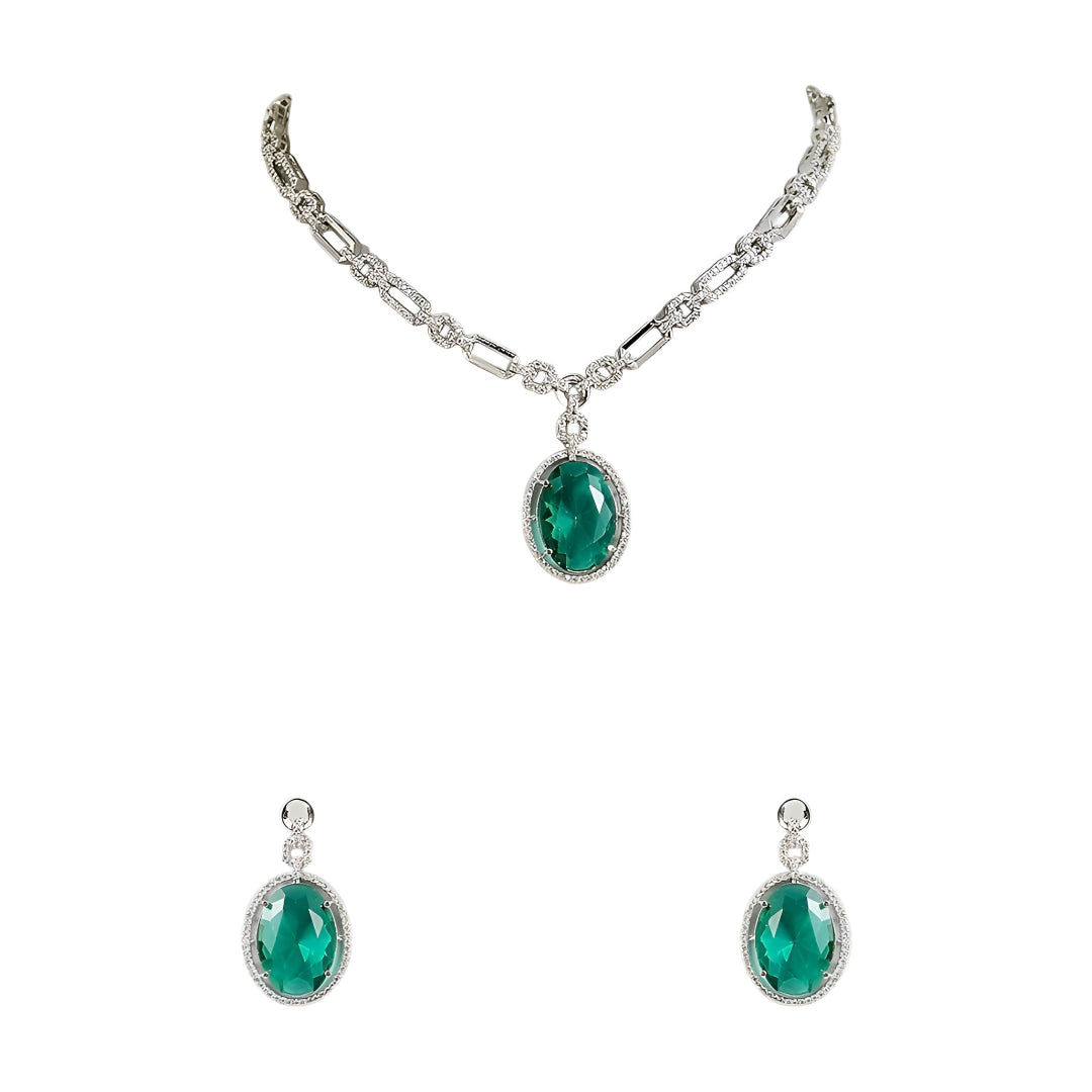 Silver-toned necklace set featuring an emerald green oval crystal pendant with matching drop earrings on a white background.