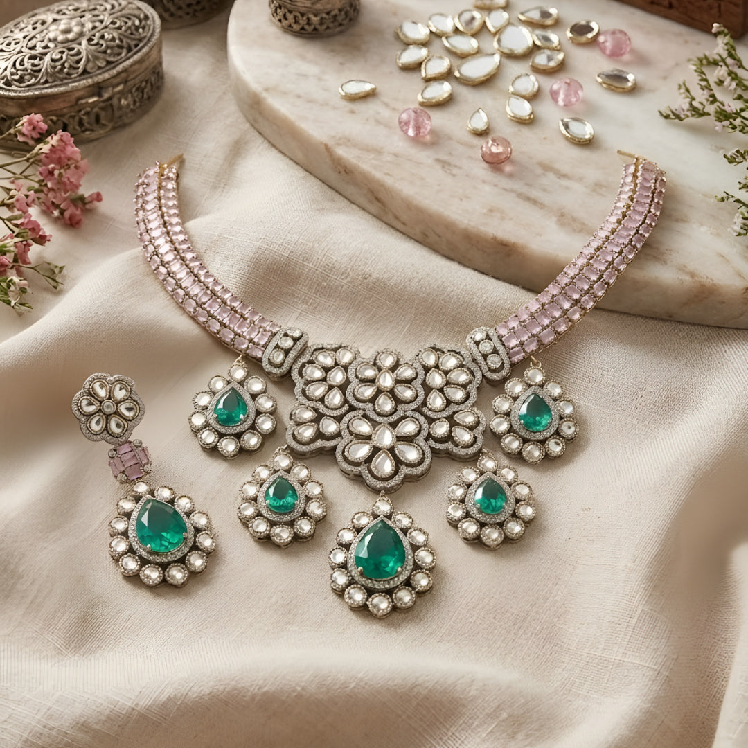 Traditional emerald green kundan choker necklace set with floral motifs and matching drop earrings for bridal and festive wear.