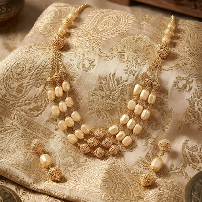 Elegant multi-layer ivory pearl beaded necklace set with gold-tone filigree accents and matching drop earrings for women.