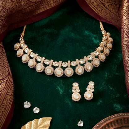 Gold-tone statement necklace set with ivory cabochon stones, crystal embellishments, and matching earrings on white background.
