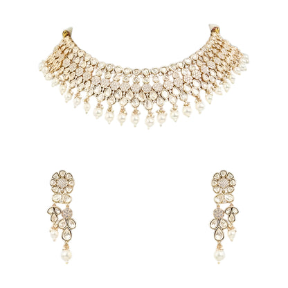 Gold-toned Kundan pearl choker necklace set featuring floral motifs, teardrop stones, pearl danglers, and matching earrings on a white background.