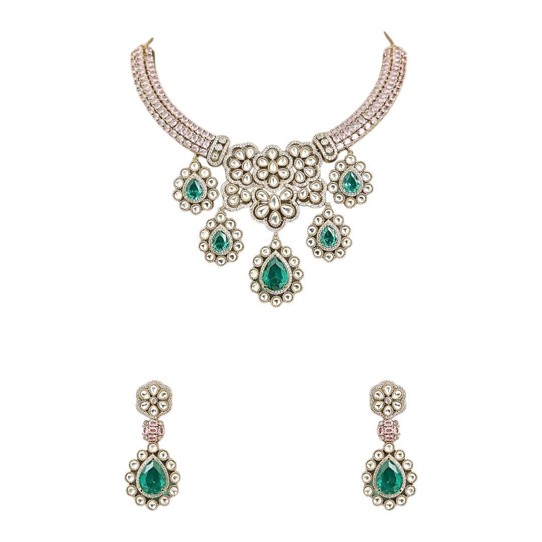 Traditional emerald green kundan choker necklace set with floral motifs and matching drop earrings for bridal and festive wear.