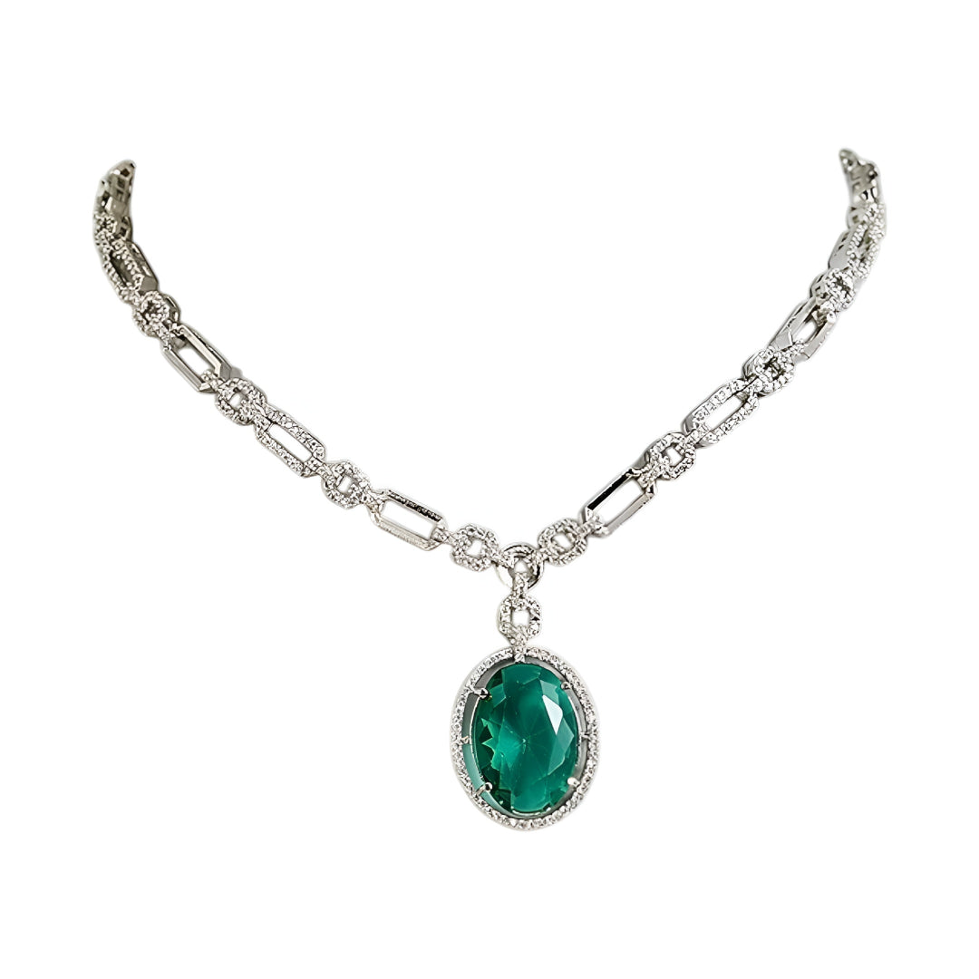 Silver-toned necklace set featuring an emerald green oval crystal pendant with matching drop earrings on a white background.