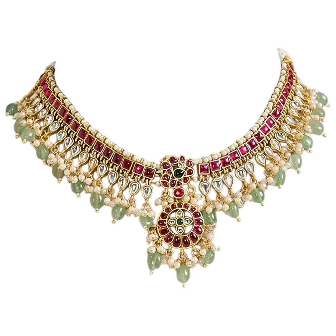 Traditional Kundan choker necklace set with ruby stones, green bead drops, gold finish, and matching earrings for bridal and wedding wear.