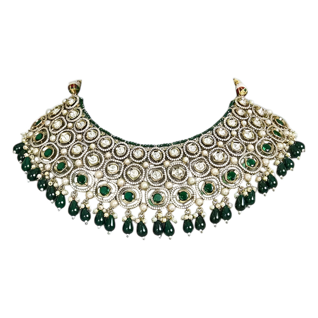 Traditional green Kundan choker necklace set with Polki stones, pearl detailing, green bead drops, and matching jhumka earrings for bridal and wedding wear.