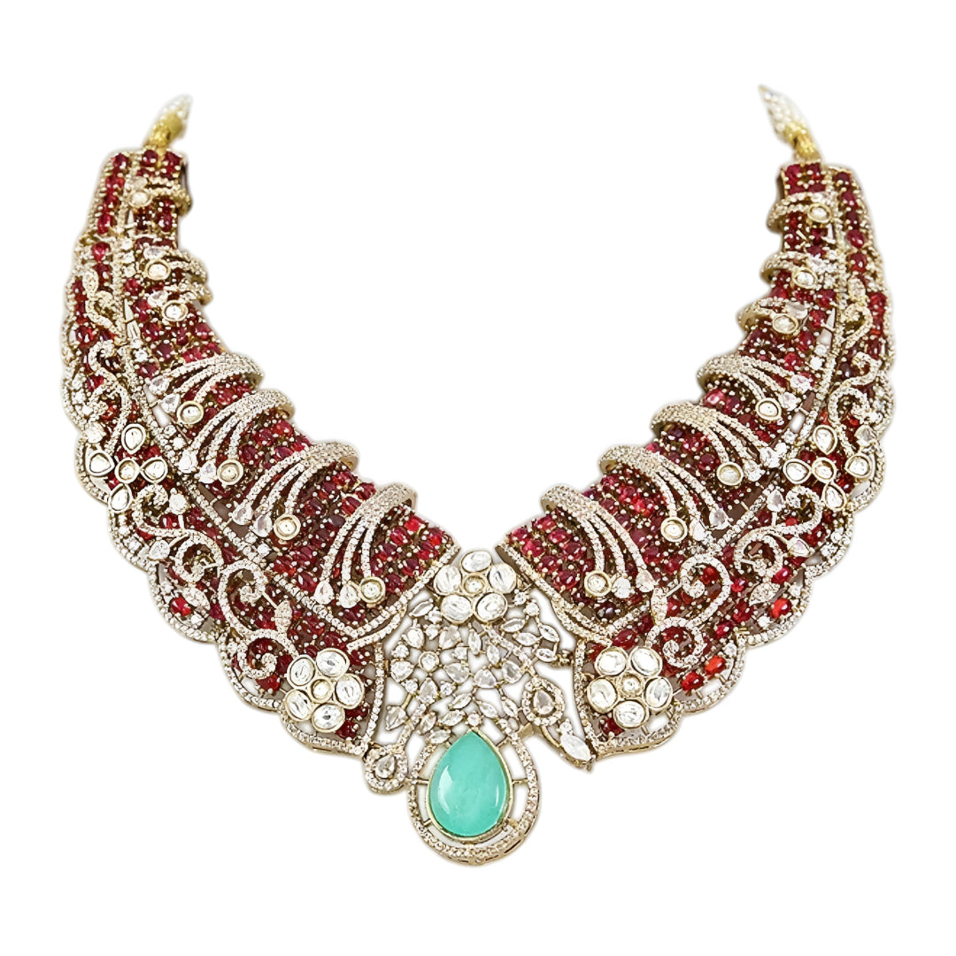 Designer ruby red kundan choker necklace set with sparkling crystal detailing, mint green teardrop gemstone centerpiece, and matching earrings for bridal and festive occasions.