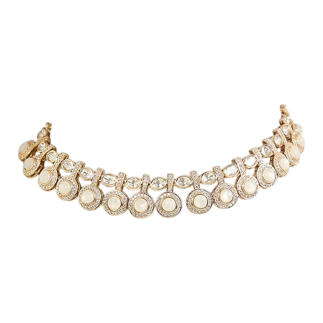 Gold-tone statement necklace set with ivory cabochon stones, crystal embellishments, and matching earrings on white background.