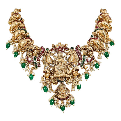 Traditional South Indian Temple Jewellery Lakshmi Necklace Set with matching Jhumka Earrings, antique gold finish, green bead drops, and ruby stone embellishments for bridal and festive wear.