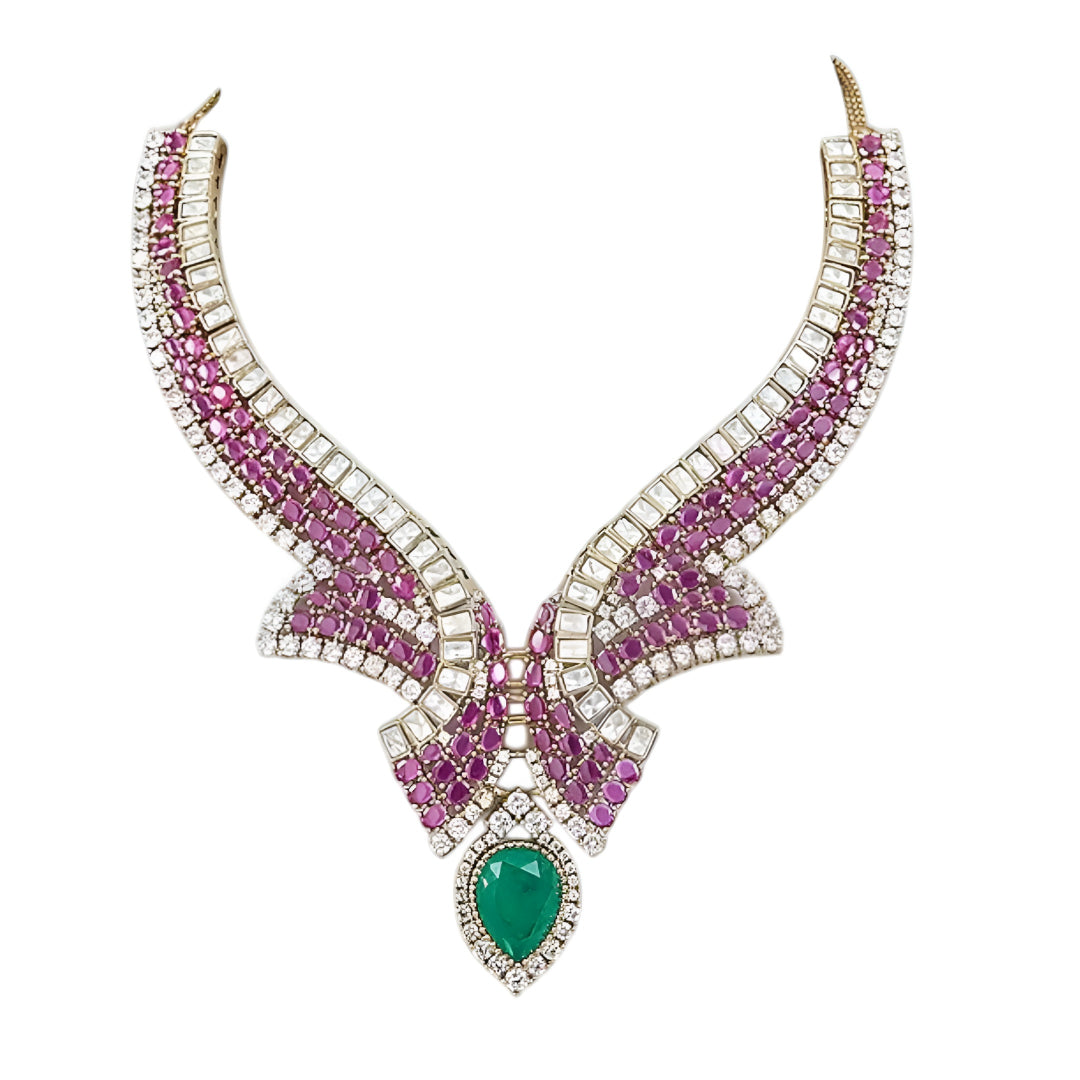 Luxury emerald, ruby and diamond necklace set with matching earrings in white gold featuring pear-shaped emerald gemstones, pink ruby accents and sparkling diamond detailing.