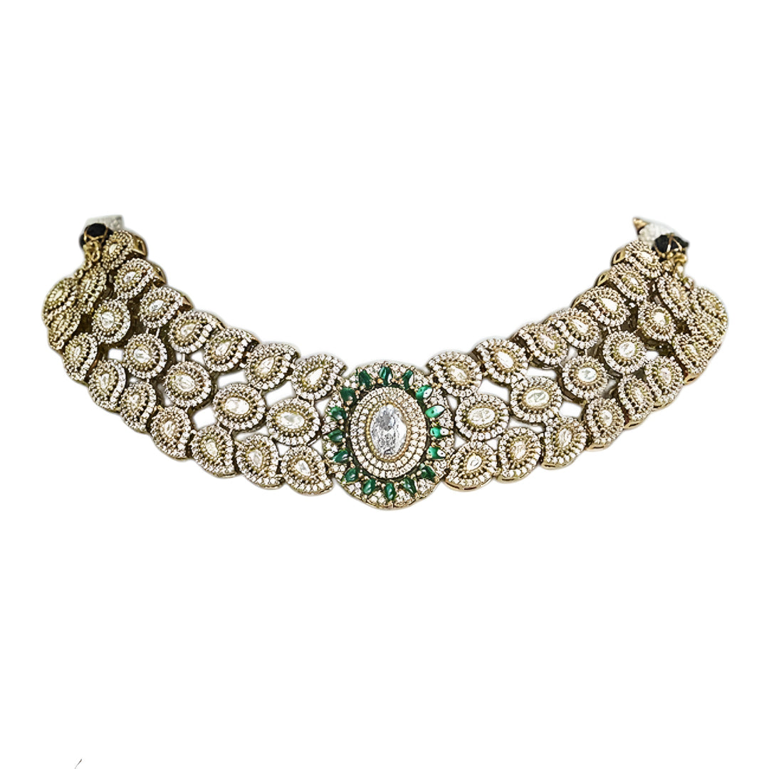 Elegant diamond and emerald choker necklace set with matching stud earrings featuring intricate floral motifs, sparkling white stones, green gemstone accents, and a luxurious gold-tone finish.