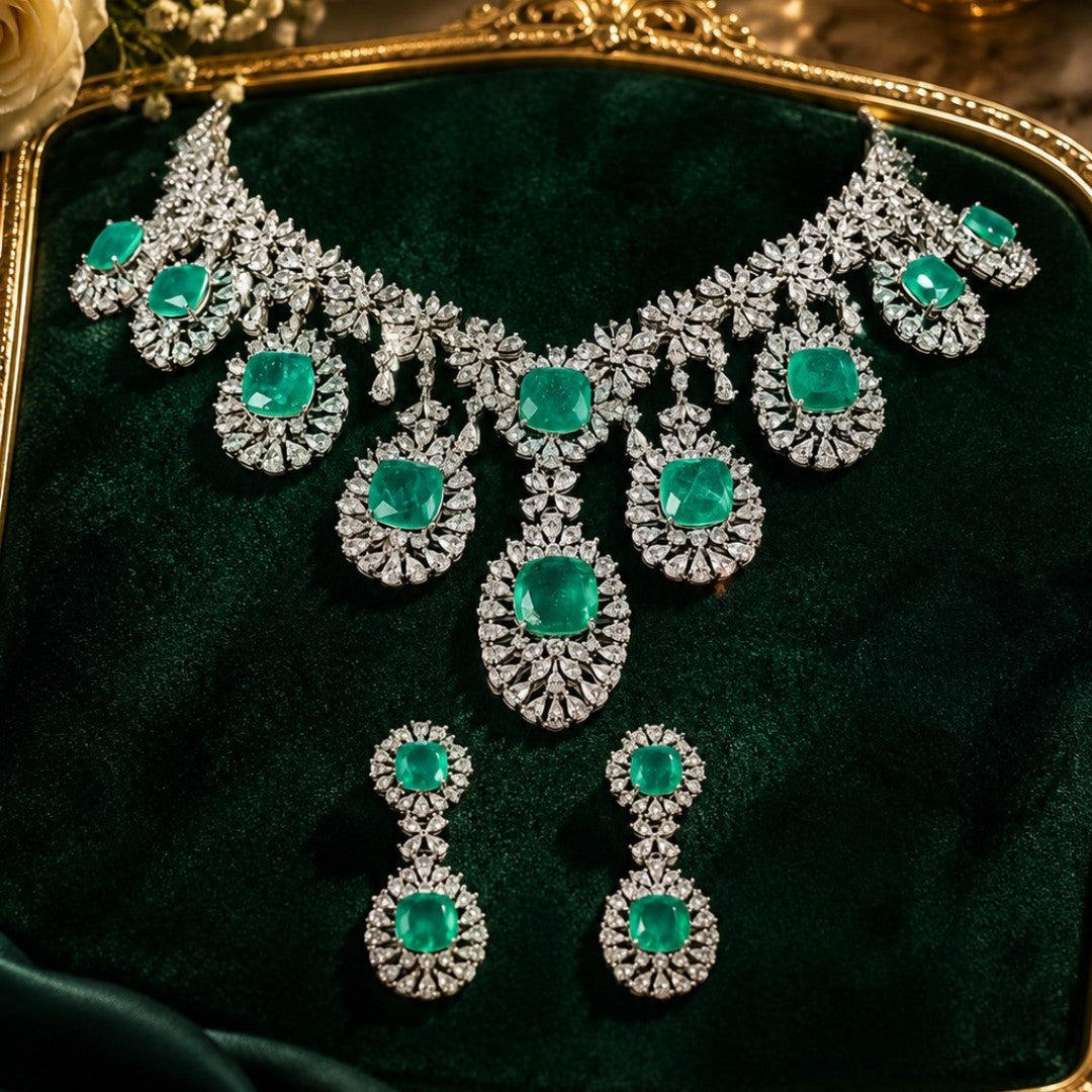 "Silver rhodium-plated multi-tier bridal necklace set with white American diamonds and cushion-cut emerald green stones, paired with matching drop earrings"