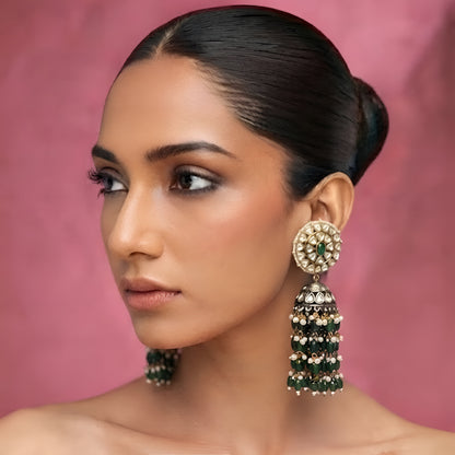 Green Kundan jhumka earrings with gold plating, emerald green center stone, pearl accents, and layered green bead tassels for bridal and festive wear.