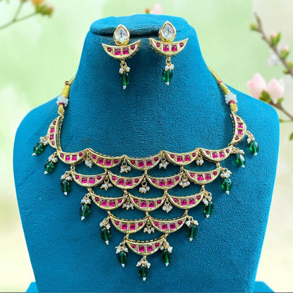 Gold-finish kundan crescent-tier necklace set with ruby-pink stones, green bead and pearl hangings and matching pear-top earrings
