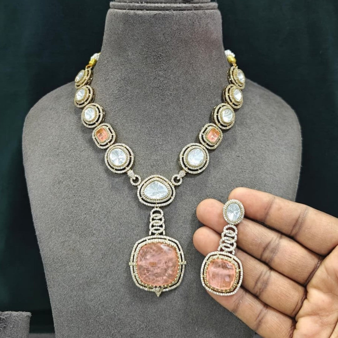 Antique gold Victorian kundan necklace with a large square peach-pink pendant and matching drop earring on a grey display bust