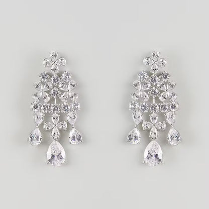 "Silver-plated floral chandelier earrings with cubic zirconia stones and pear-shaped crystal drops, product shot on grey background"