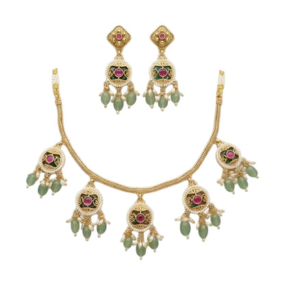 Antique gold plated necklace set with round ruby pink medallions, pastel green bead and pearl drops and matching earrings on a blue bust
