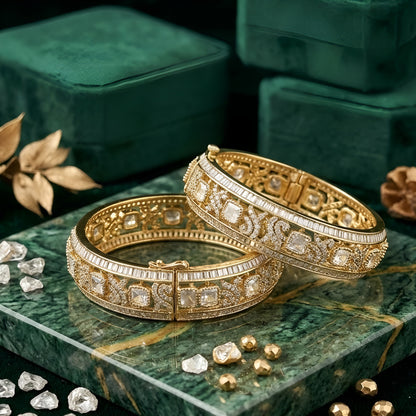 Pair of gold-finish openable kada bangles with polki-style clear square stones, Victorian-style scrollwork, and baguette-cut American diamond edges
