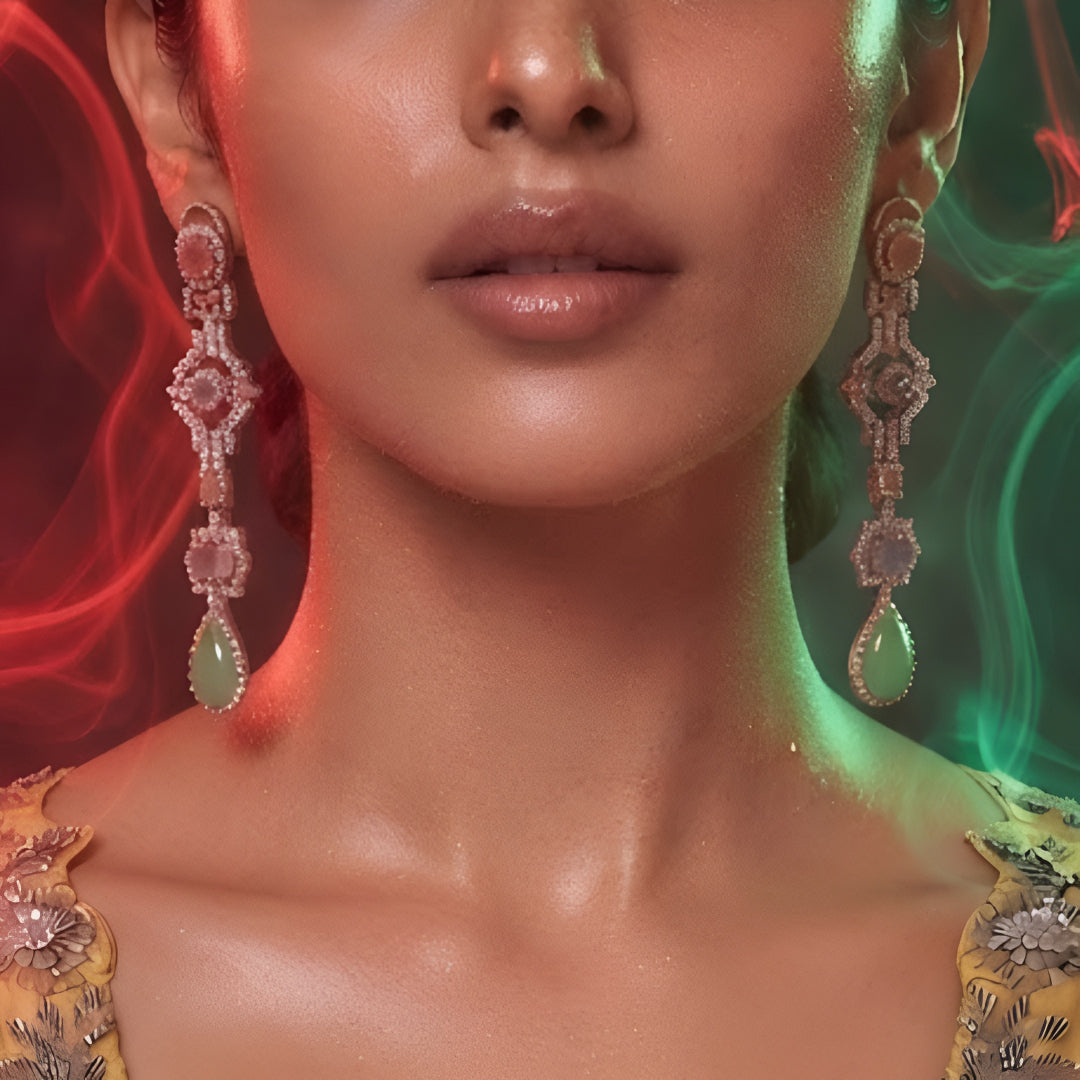 "Long gold-tone jhumka chandelier earrings with pink stones, CZ detailing, and green teardrop stone drop, front-facing pair