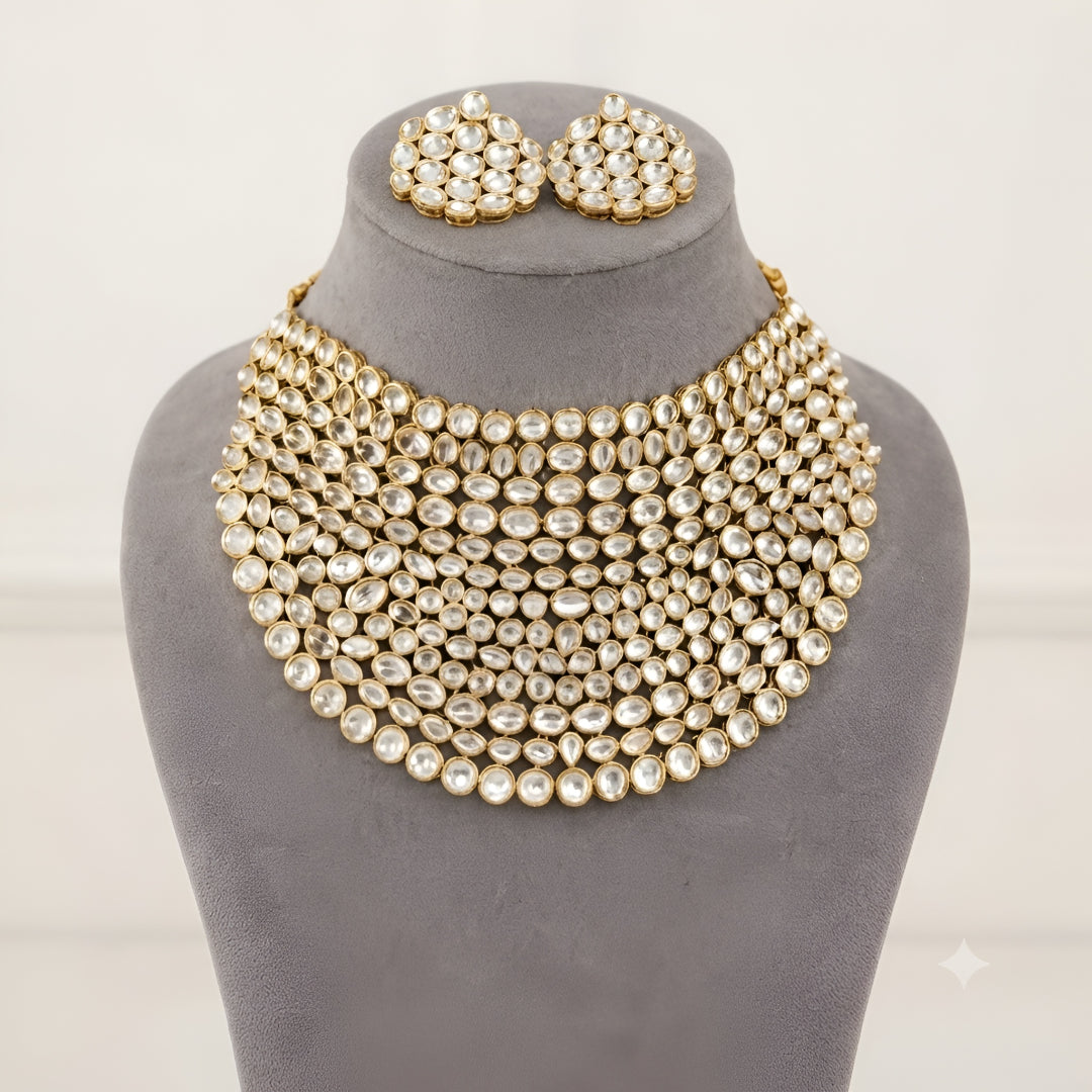 "Gold-tone kundan studded bib-style bridal necklace set with matching round stud earrings on white background"