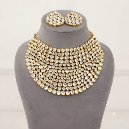 "Gold-tone kundan studded bib-style bridal necklace set with matching round stud earrings on white background"