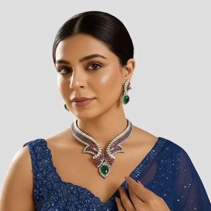 "Gold-plated designer necklace set with ruby stones, white crystals, and emerald teardrop centerpiece, paired with matching earrings"