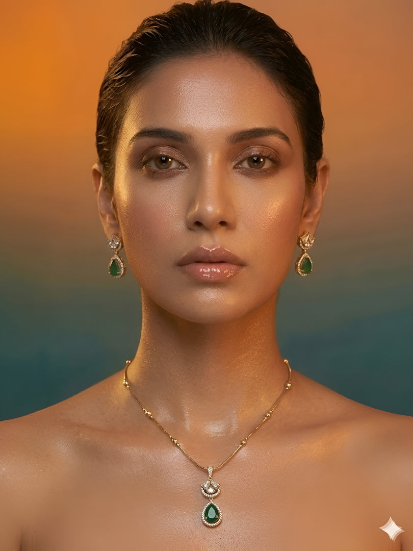 Gold-plated necklace set featuring emerald green teardrop pendant and matching drop earrings embellished with American diamonds.