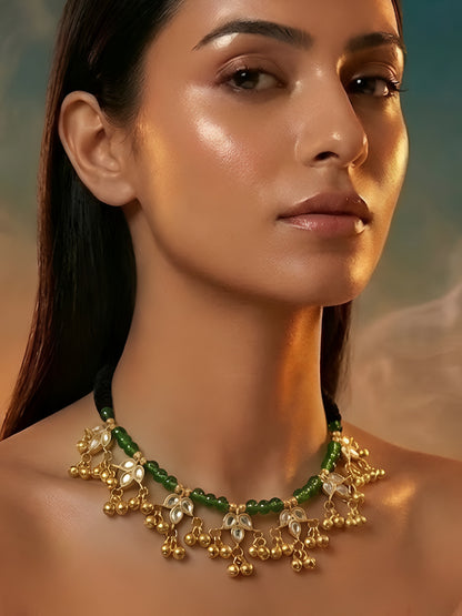 Traditional gold-plated Kundan choker necklace featuring green beads, black thread design, and decorative ghungroo danglers for women.