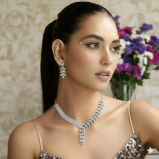Elegant leaf design American diamond necklace with green stone detailing and matching earrings on red velvet display stand