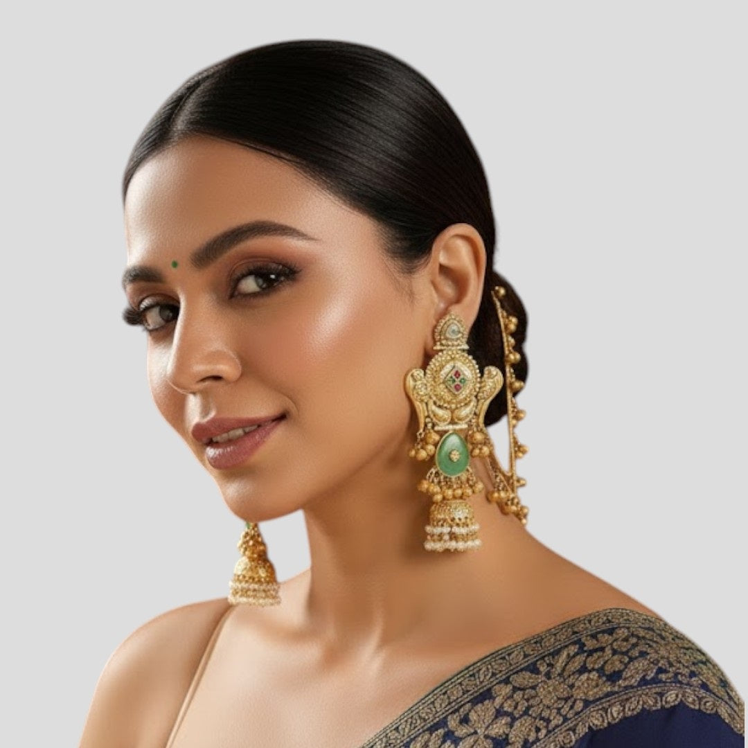 "Pair of gold-plated temple-style earrings featuring Goddess Lakshmi, mint-green stone accents, kundan details, pearl drops, and attached decorative ear chains with golden ghungroo charms."