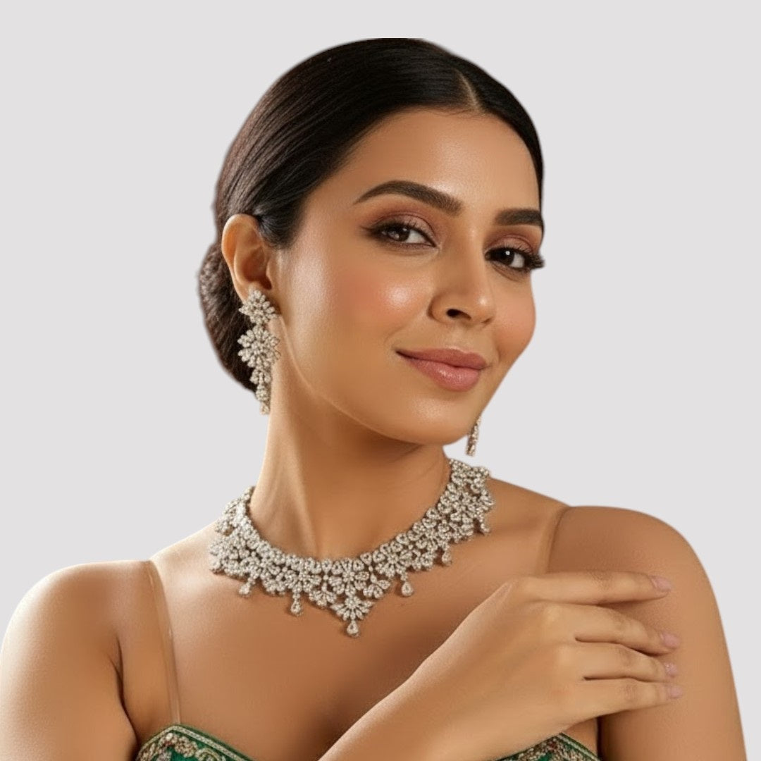 “Silver-tone crystal necklace with matching dangling earrings featuring floral and teardrop stone design.”