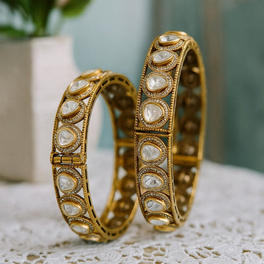 Antique Mehandi polish gold-plated bangles with dome-cut white Kundan stones, placed on a dark green fabric – traditional Indian bridal kada set