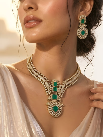 Gold-plated American diamond necklace set with emerald green stones and matching earrings for women, perfect for bridal, wedding, festive, and party wear.