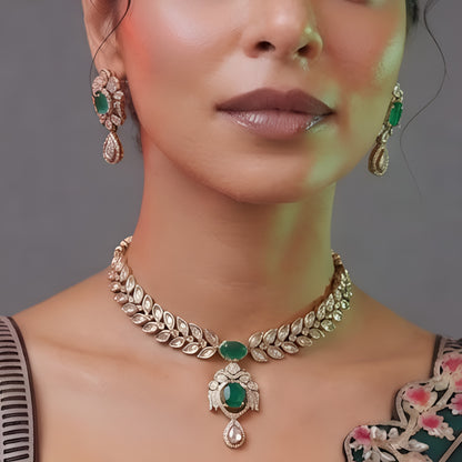 Woman wearing an emerald-green leaf-design kundan necklace set with pendant and matching drop earrings