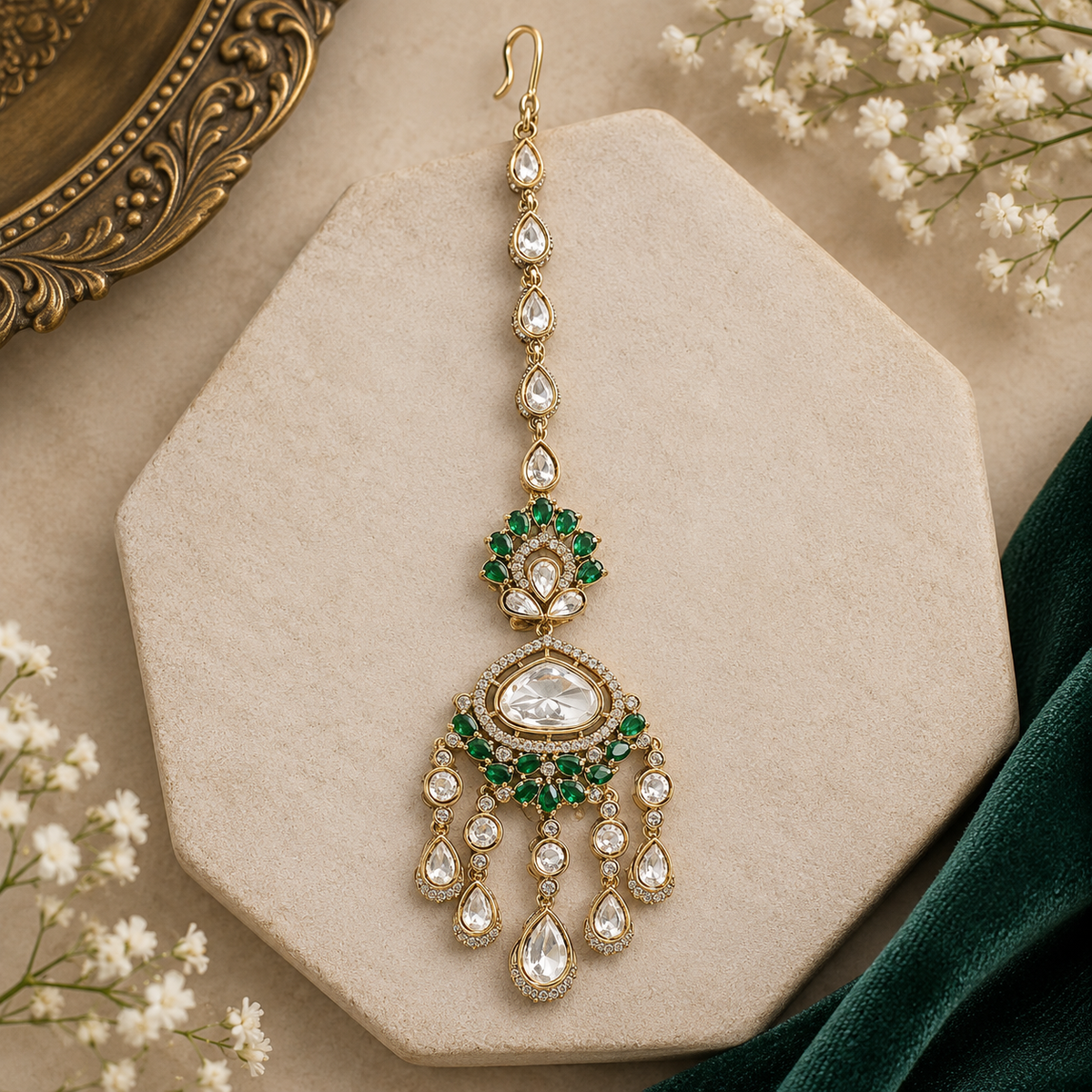 Gold finish kundan polki maang tikka with emerald green pear-stone fan, large clear centre stone, American diamond halo and chandelier-style kundan drops – Auraa Trends
