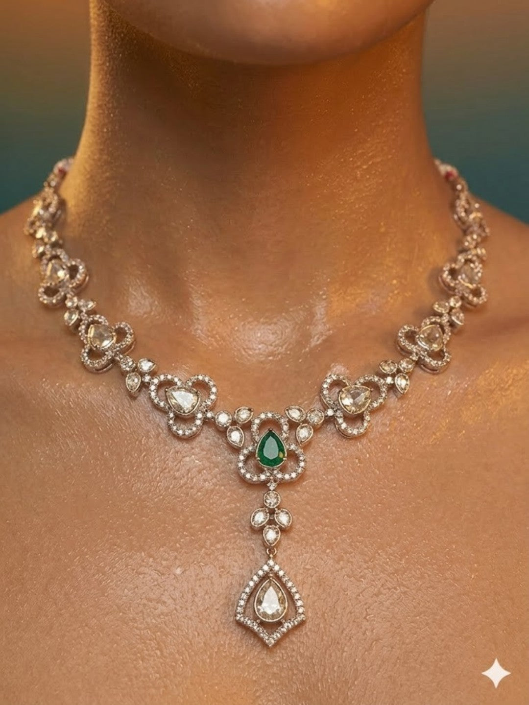 Gold-plated necklace set featuring green stones, American diamonds, floral motifs, and matching drop earrings for women.