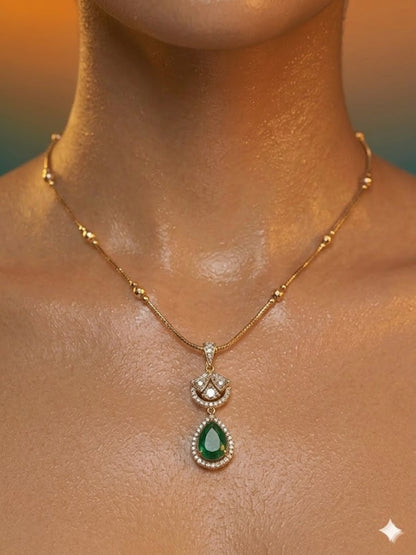 Gold-plated necklace set featuring emerald green teardrop pendant and matching drop earrings embellished with American diamonds.