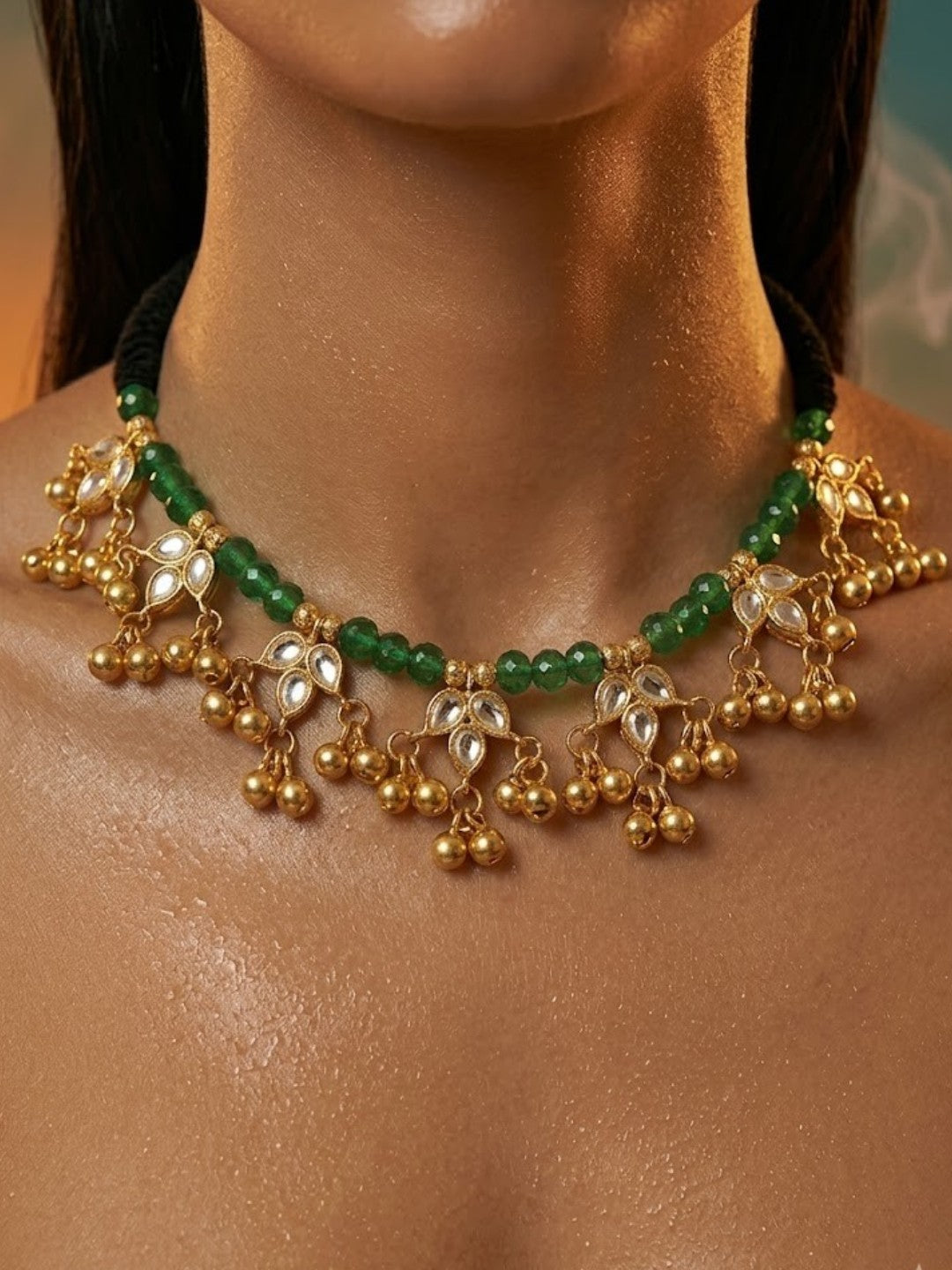 Traditional gold-plated Kundan choker necklace featuring green beads, black thread design, and decorative ghungroo danglers for women.