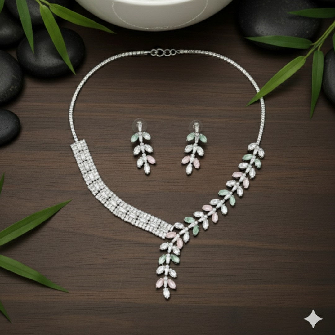Elegant leaf design American diamond necklace with green stone detailing and matching earrings on red velvet display stand